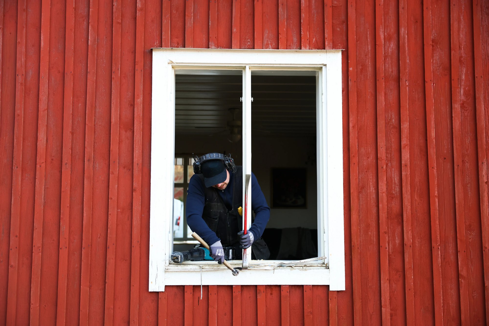 Montör monterar ett fönster i ett rött hus