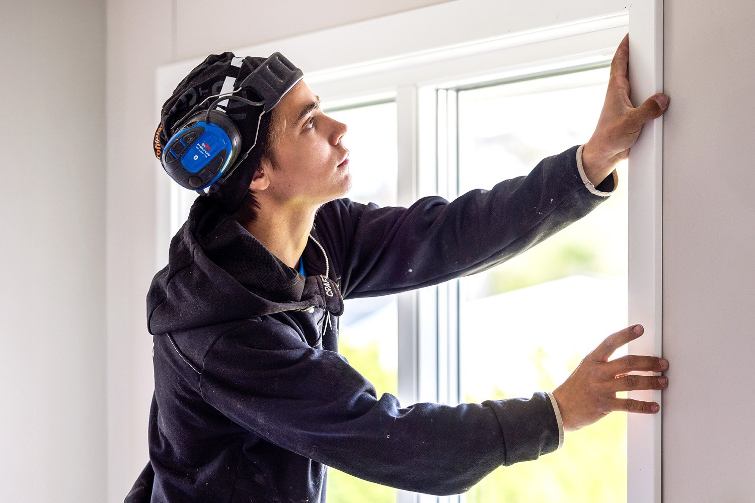 Montör justerar och installerar ett fönster inomhus.