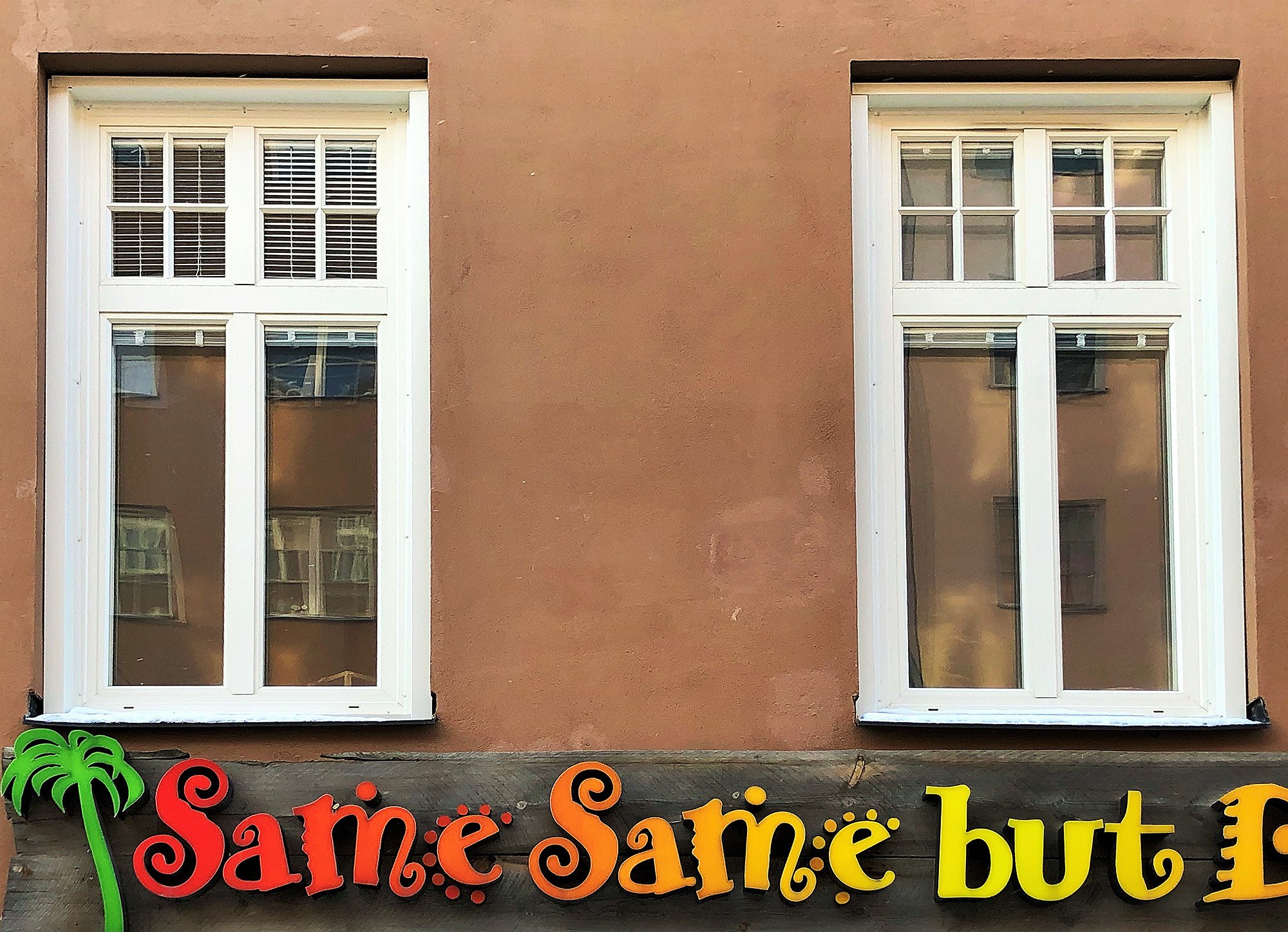 Nybytta spröjsade fönster med vita karmar på rosa putsfasad – fönsterbyte i BRF Bonden 29 på Södermalm, Stockholm.