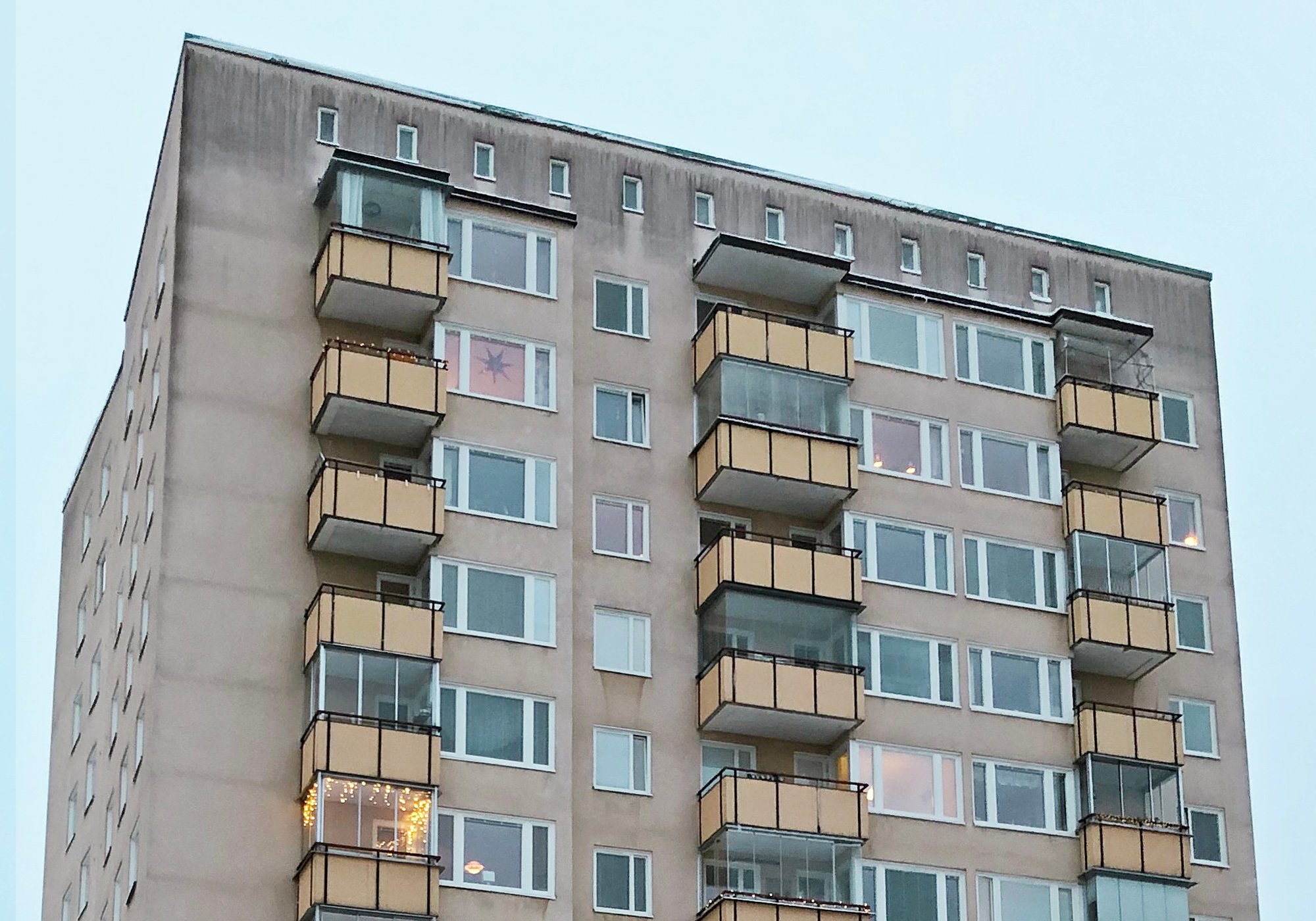 Närbild på nybytta fönster med vita karmar och inglasade balkonger på höghus – del av byte av ca 400 fönster utfört av Mockfjärds.