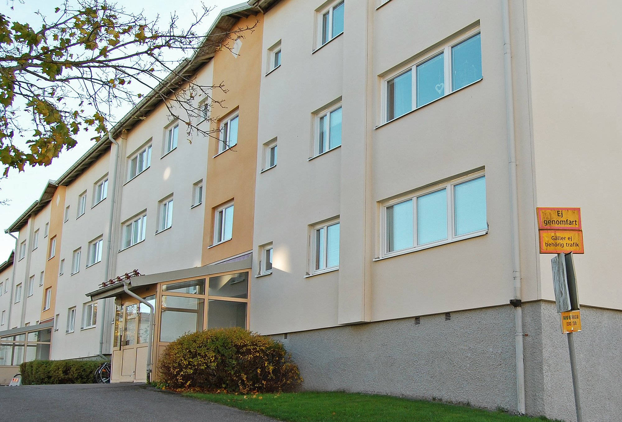 Exteriör av flervåningshus med ljus putsfasad och nybytta fönster med vita karmar – byte av ca 300 fönster utfört av Mockfjärds.