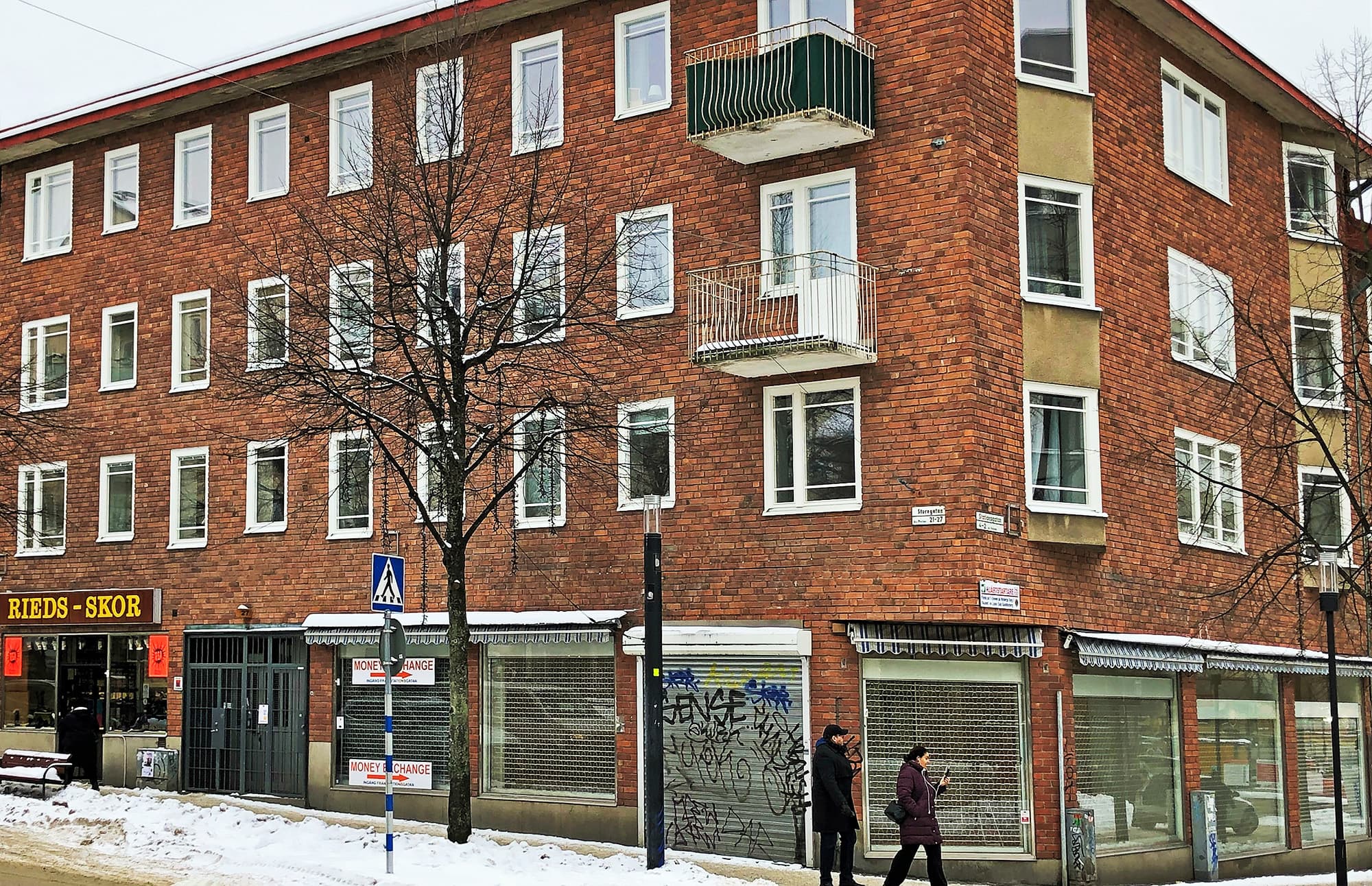 Fönsterbyte på flervåningshus i rött tegel på Sturegatan 27 i Sundbyberg – exteriör med butikslokaler i bottenvåningen.
