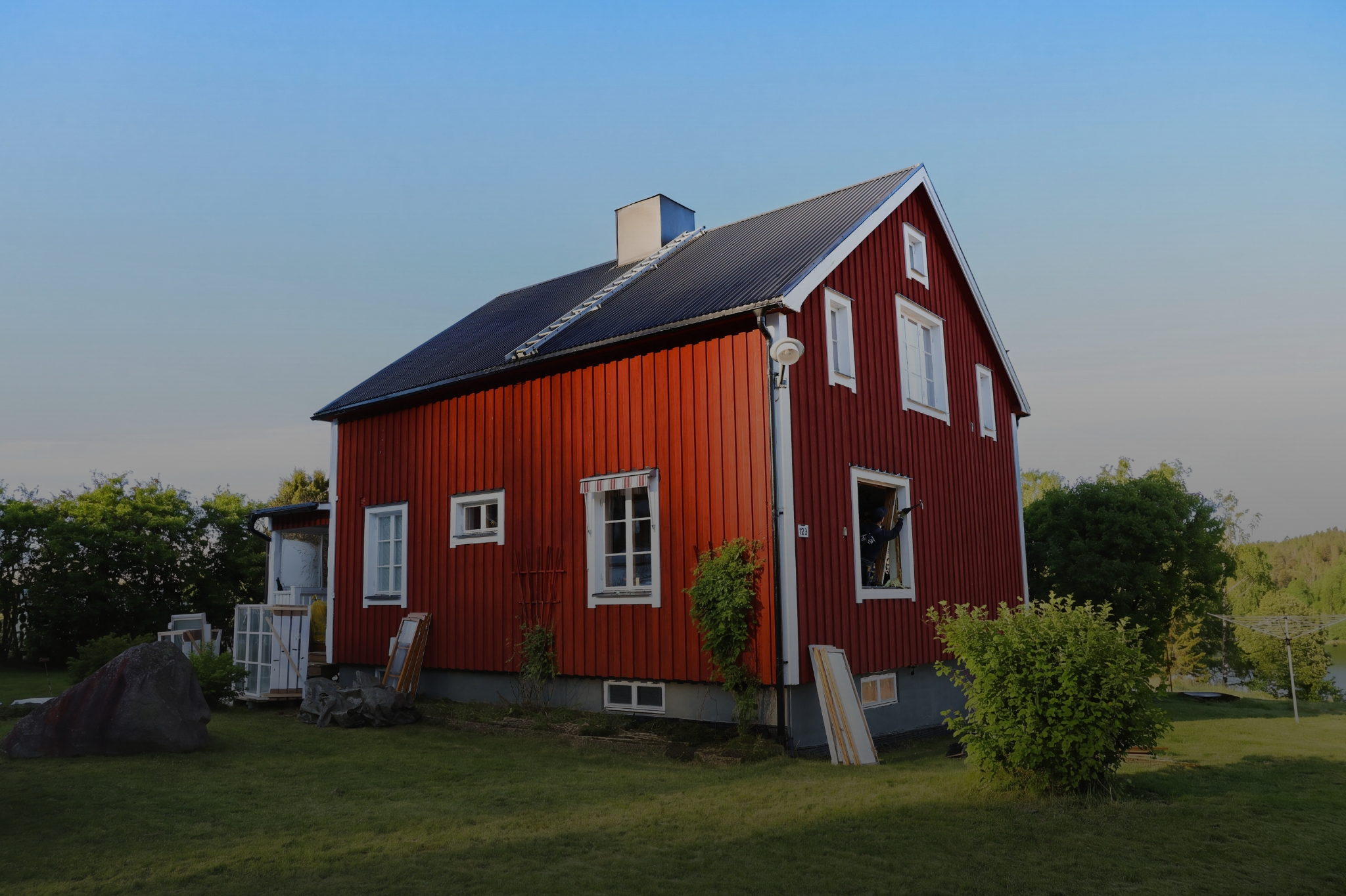 Ett rött hus med blå himmel och grönt gräs