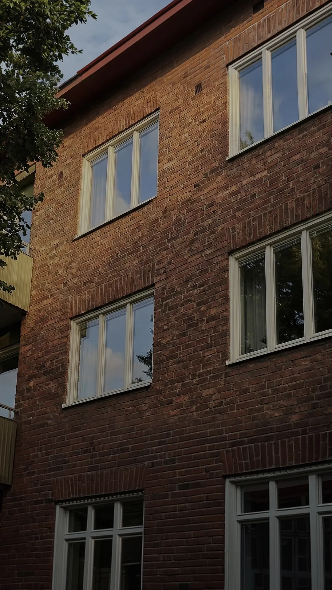 Fasad med flera fönster på ett flerbostadshus.