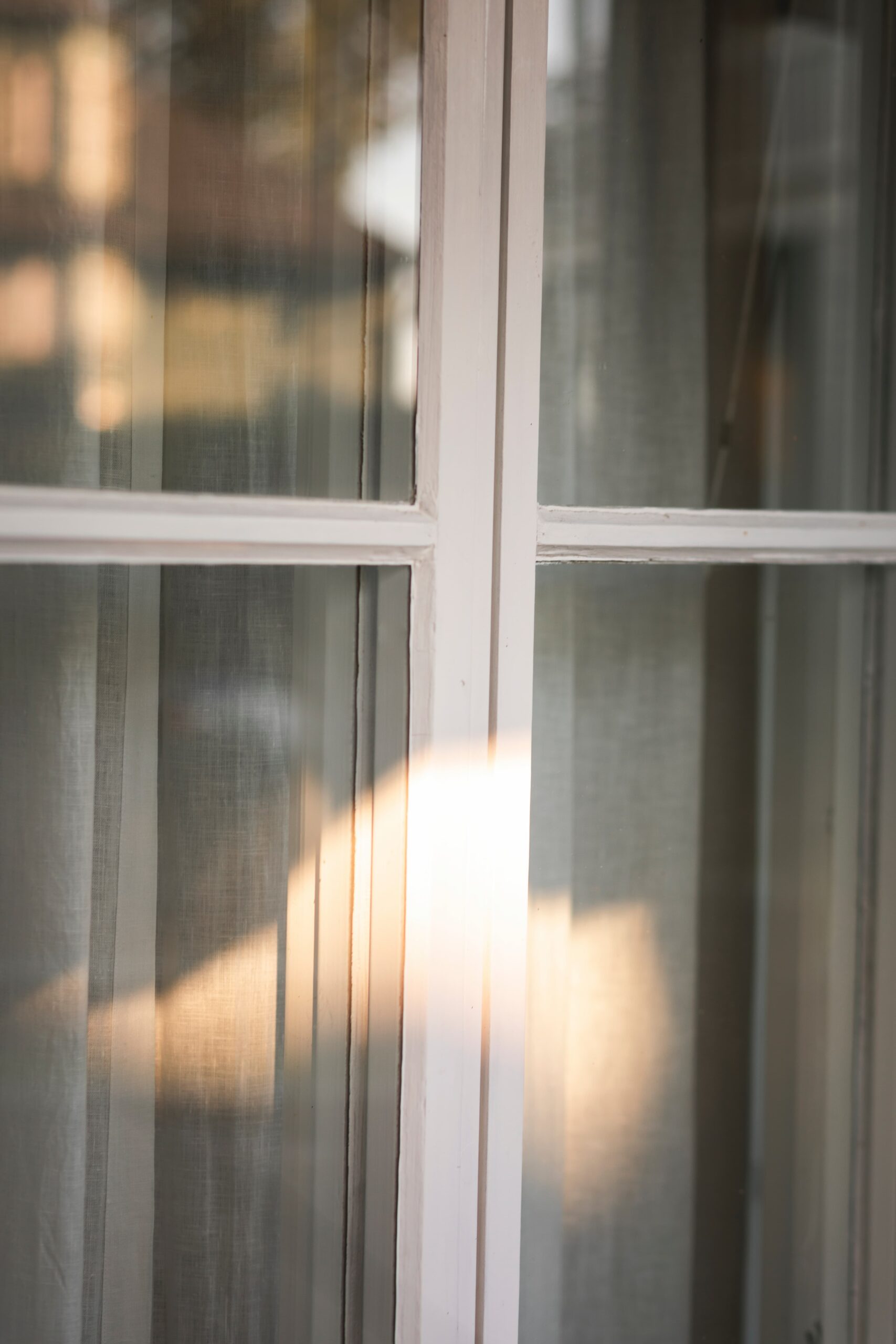 Närbild på spröjsat fönster med vit karm och persienner – Svanenmärkt 3-glasfönster med solskyddsglas i Fågelbro 7 på Värmdö.