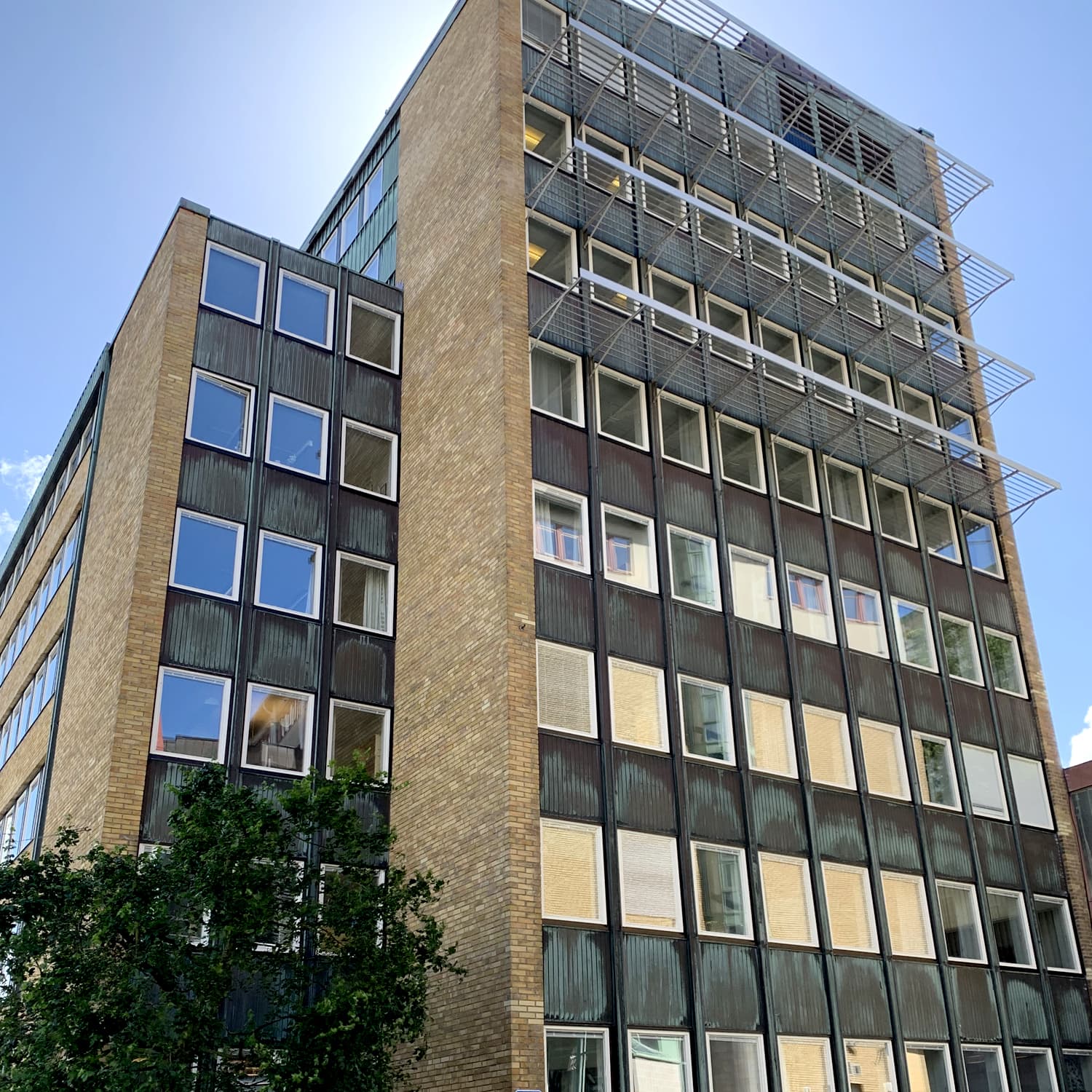 Fasadvy av flervåningshus på Ekelundsgatan med stora fönsterpartier och solskyddsgaller – fönsterbyte och fogsanering med kvarboende hyresgäster utfört av Mockfjärds.