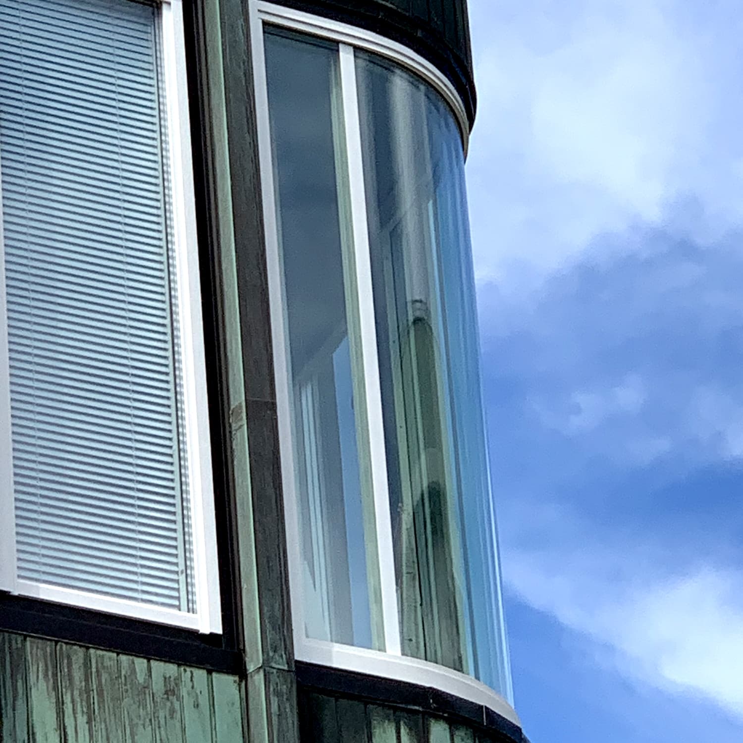 Närbild på nybytt böjt hörnfönsterparti med vita karmar – unikt fönsterbyte på Ekelundsgatan i Göteborg utfört av Mockfjärds med alla hyresgäster kvar.