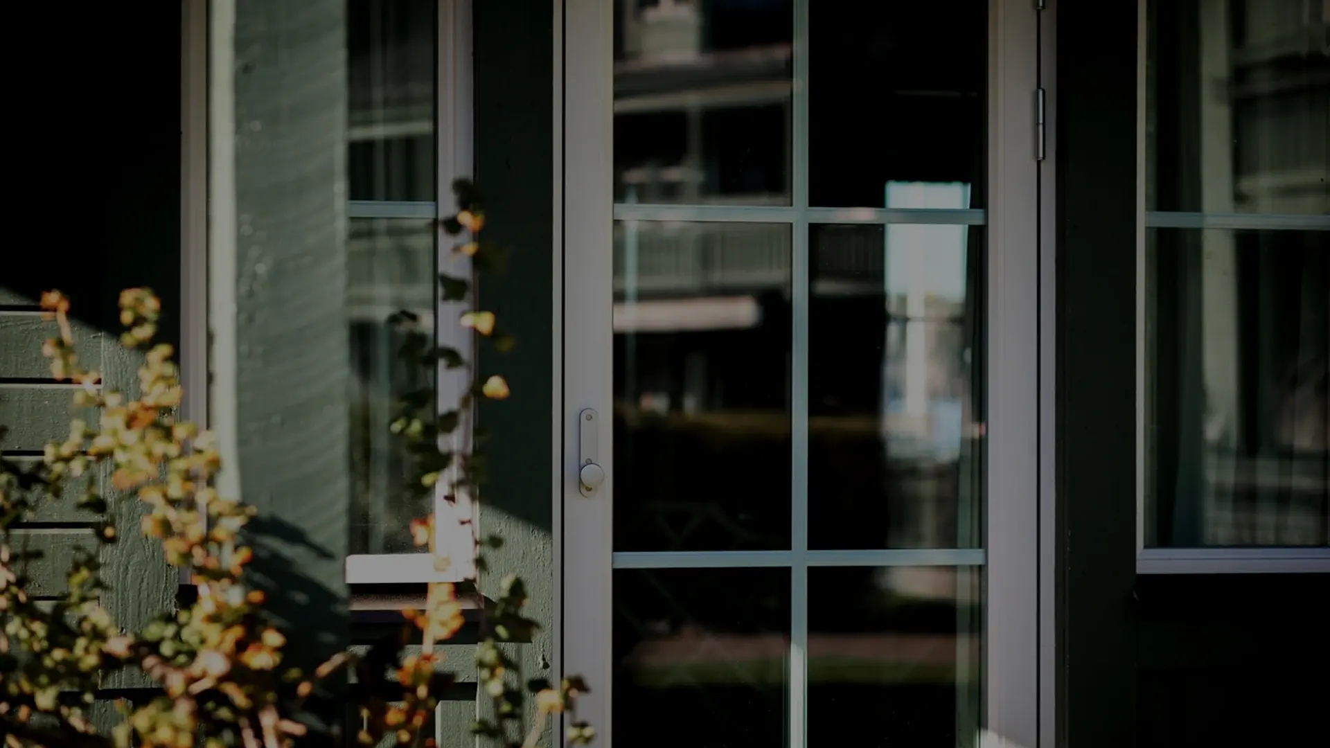 Utåtgående balkongdörr med spröjs och vit karm på grön träfasad – nytt Svanenmärkt fönster i aluminiumbeklätt trä, Fågelbro 7, Värmdö.